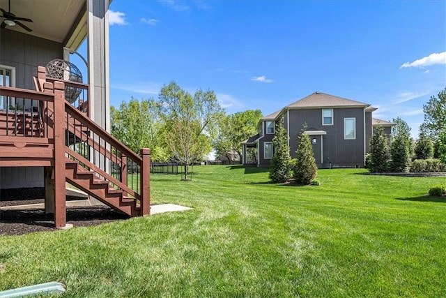 view of yard with a ceiling fan and stairs