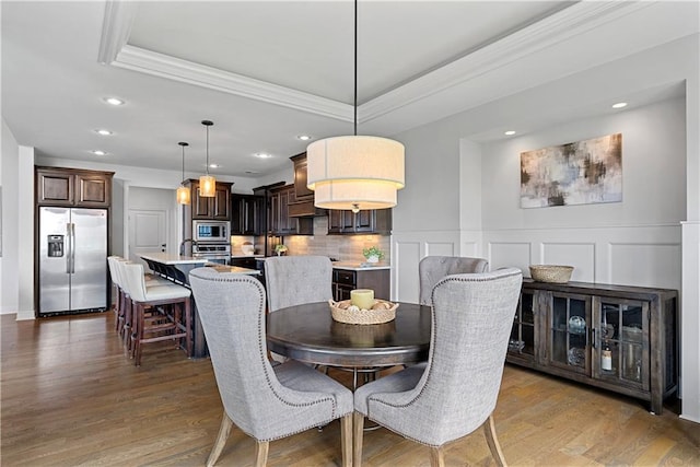 dining space with ornamental molding, recessed lighting, and wood finished floors