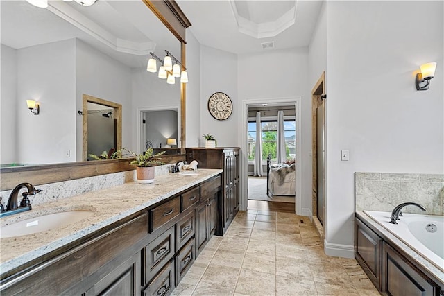 full bathroom featuring double vanity, baseboards, a sink, and a garden tub