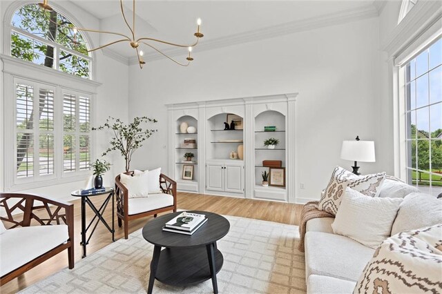 14215 W 157th Ter, Olathe, KS 66062 - living area featuring a chandelier, light wood-style flooring, a high ceiling, and crown molding