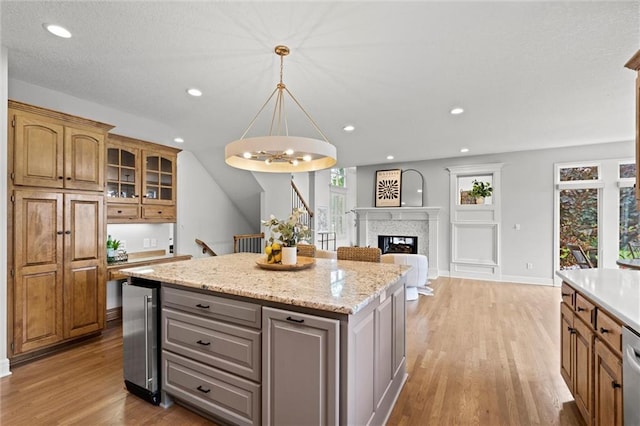14215 W 157th Ter, Olathe, KS 66062 - kitchen with wine cooler, light wood-style floors, a center island, a chandelier, and hanging light fixtures