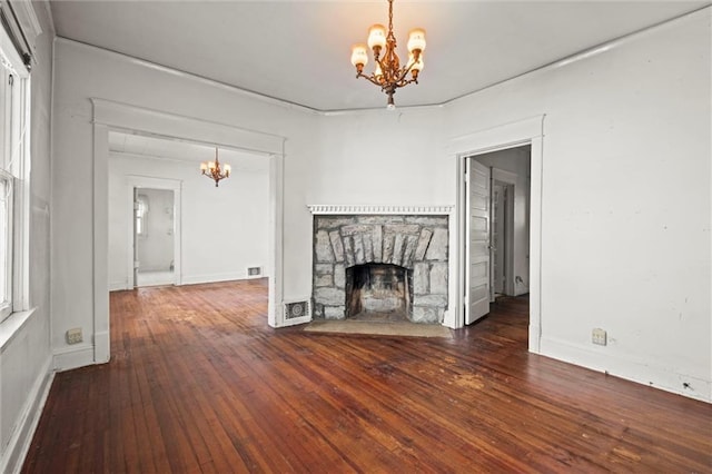 unfurnished living room featuring a fireplace, a chandelier, and hardwood / wood-style floors