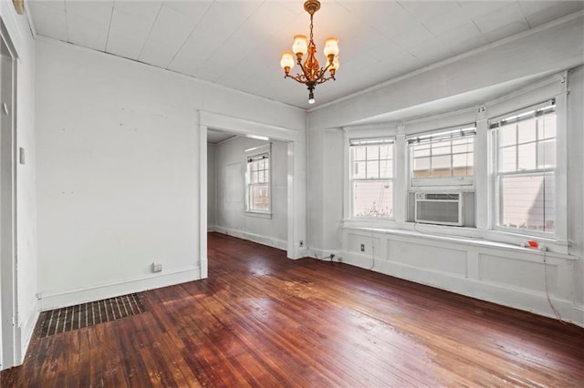 unfurnished dining area featuring an inviting chandelier, baseboards, wood-type flooring, and cooling unit