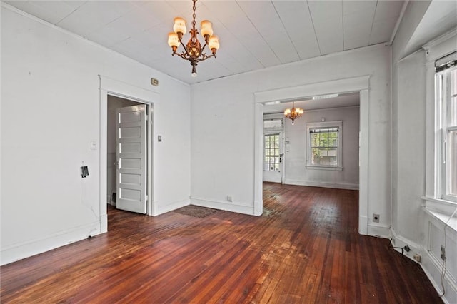 unfurnished dining area with an inviting chandelier, baseboards, ornamental molding, and wood-type flooring