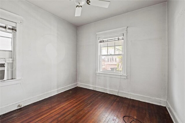 empty room featuring baseboards, ceiling fan, and dark wood-type flooring