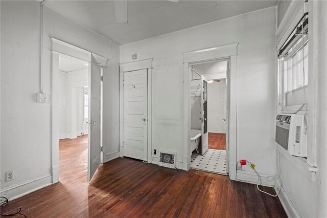 unfurnished bedroom featuring wood-type flooring, cooling unit, and visible vents