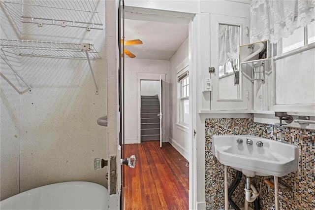 bathroom featuring a freestanding bath and wood finished floors