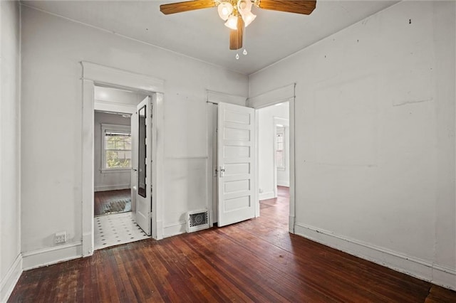unfurnished bedroom featuring baseboards, wood-type flooring, a ceiling fan, and visible vents