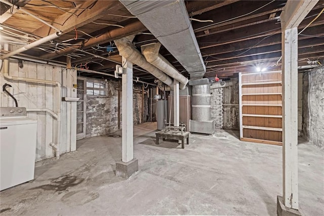 unfinished below grade area featuring washer / dryer, heating unit, and gas water heater