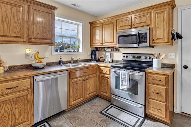 204 Lynn St, Lathrop, MO 64465 - kitchen with stainless steel appliances, a sink, light tile patterned flooring, and brown cabinets