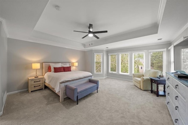bedroom with crown molding, ceiling fan, light colored carpet, baseboards, and a tray ceiling