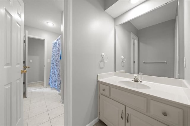 bathroom with baseboards, vanity, and tile patterned floors