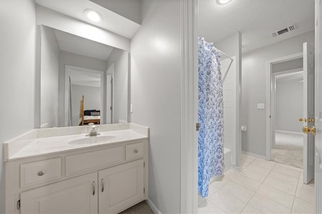 full bath featuring tile patterned flooring, vanity, a shower with shower curtain, baseboards, and visible vents
