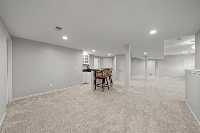 finished basement with baseboards, light carpet, and recessed lighting