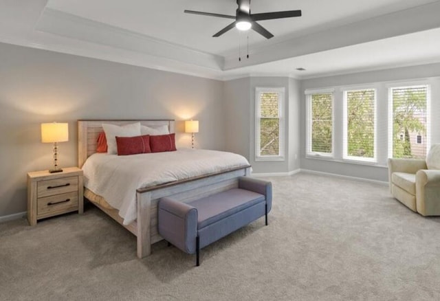 bedroom with baseboards, carpet floors, a tray ceiling, and ceiling fan