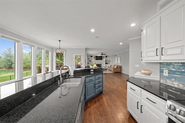 kitchen featuring crown molding, open floor plan, recessed lighting, white cabinets, and a sink