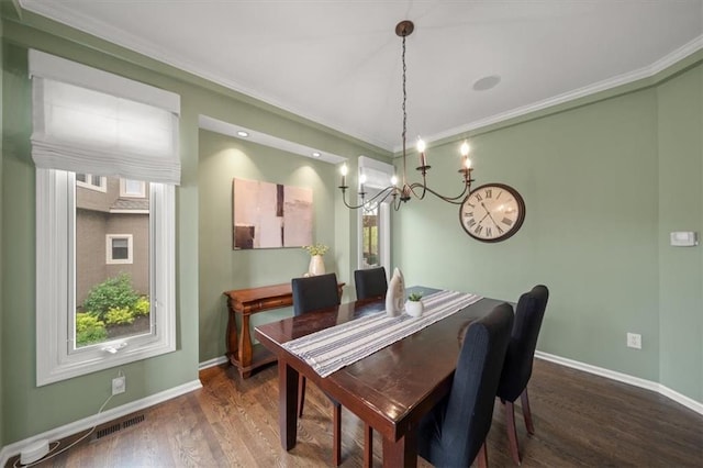 dining area with baseboards, a notable chandelier, wood finished floors, and visible vents