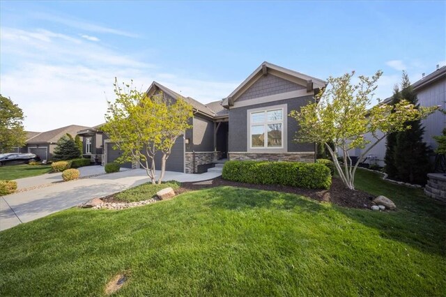view of front of house with a garage, a front lawn, driveway, and stone siding