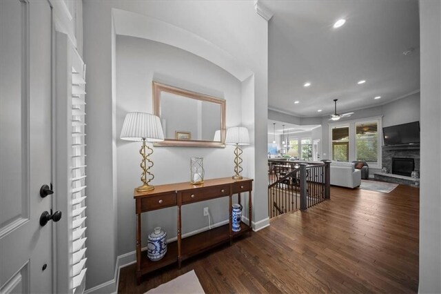 entryway with ceiling fan, a stone fireplace, recessed lighting, baseboards, and wood finished floors