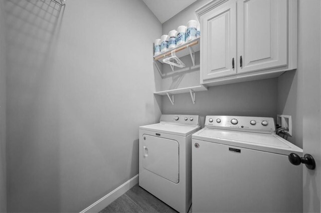 washroom with baseboards, cabinet space, and washer and dryer