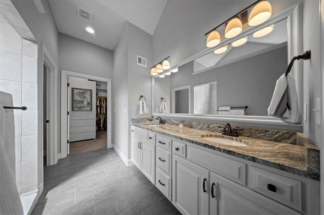 bathroom featuring double vanity, visible vents, and a sink