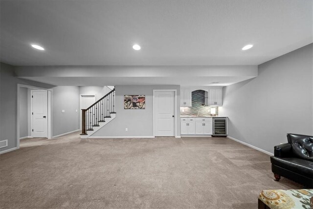 interior space featuring light colored carpet, stairs, baseboards, wine cooler, and recessed lighting