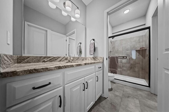 full bath with vanity, a shower stall, and toilet