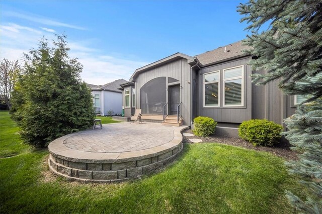 rear view of property featuring a patio area and a yard
