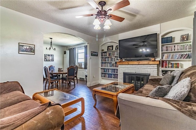401 E Jackson St, Windsor, MO 65360 - living room featuring a textured ceiling, built in shelves, ceiling fan, arched walkways, and wood-type flooring