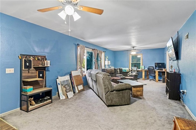 carpeted living room featuring baseboards, a textured wall, a ceiling fan, and visible vents