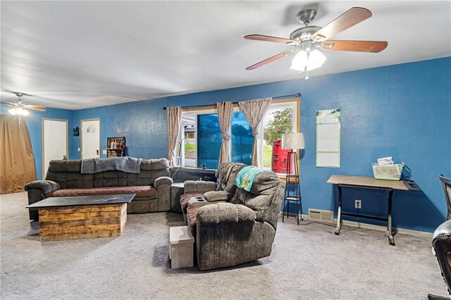 carpeted living area with a ceiling fan, baseboards, and visible vents