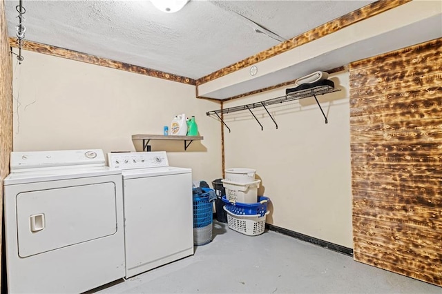 laundry area with baseboards, laundry area, washing machine and dryer, and a textured ceiling