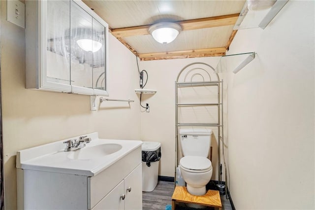 bathroom with beam ceiling, vanity, toilet, wooden ceiling, and wood finished floors