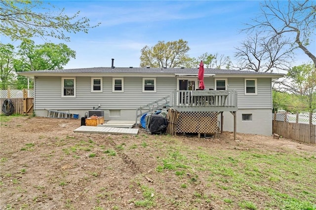 back of property featuring a fenced backyard and a deck