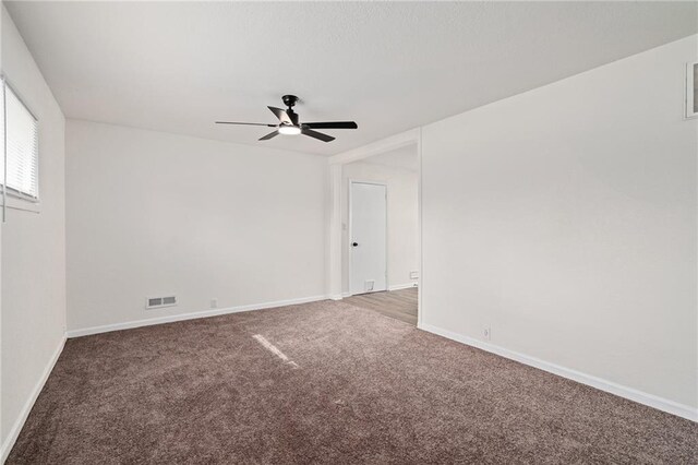 spare room with baseboards, ceiling fan, carpet flooring, and visible vents