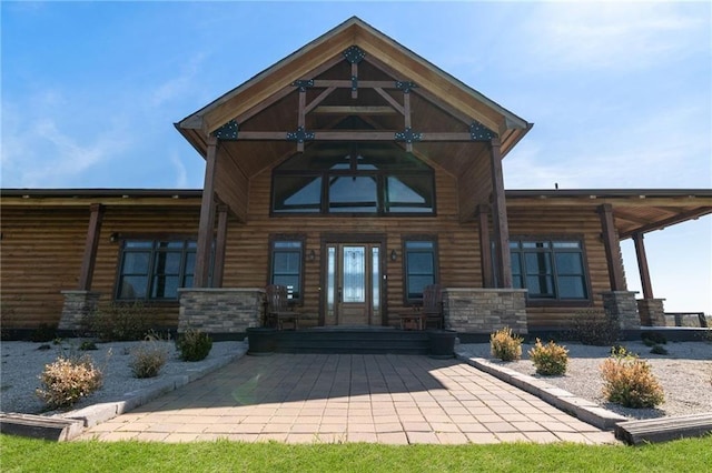 view of exterior entry featuring log veneer siding