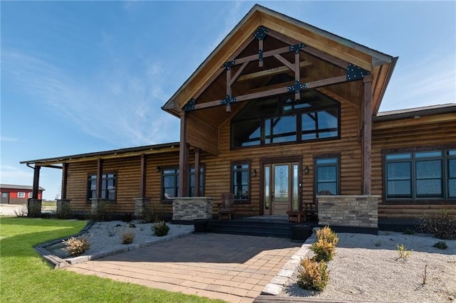 rear view of house featuring a lawn and faux log siding