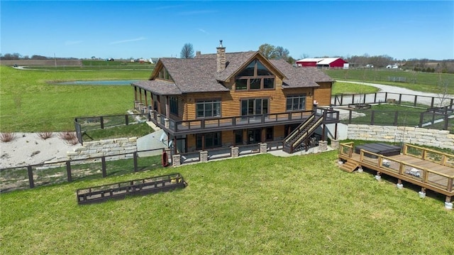 back of house featuring a fenced backyard, a chimney, a yard, and a deck