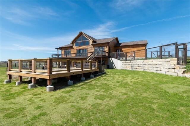 rear view of property featuring a lawn, a wooden deck, and faux log siding