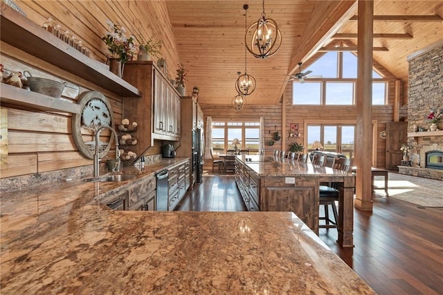 kitchen with high vaulted ceiling, dark wood-type flooring, wooden ceiling, light stone counters, and a sink
