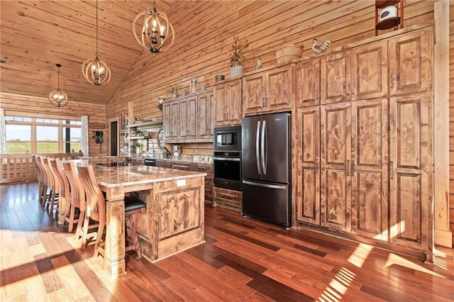 kitchen with appliances with stainless steel finishes, a breakfast bar area, high vaulted ceiling, and dark wood-style floors