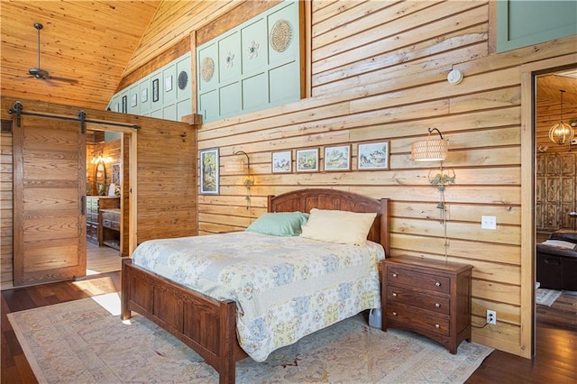 bedroom featuring wooden walls, a barn door, high vaulted ceiling, wooden ceiling, and wood finished floors