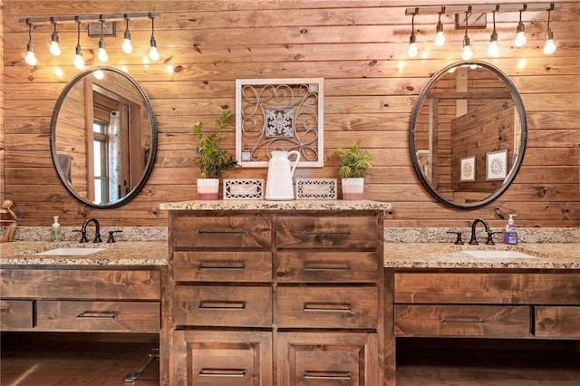 bathroom with wood walls, two vanities, and a sink