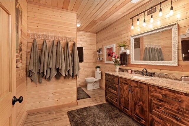 bathroom with vanity, toilet, wood walls, wooden ceiling, and wood finished floors