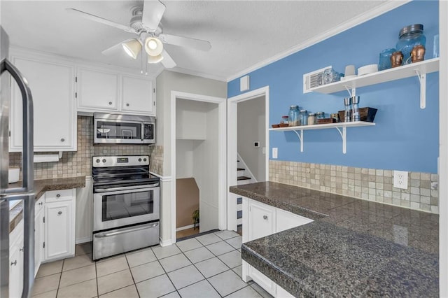 kitchen featuring stainless steel appliances, open shelves, white cabinets, a ceiling fan, and tile countertops
