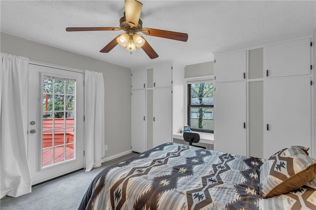carpeted bedroom with access to exterior, multiple windows, a ceiling fan, and two closets