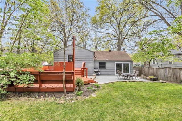 rear view of property with fence, a yard, a patio area, and a wooden deck