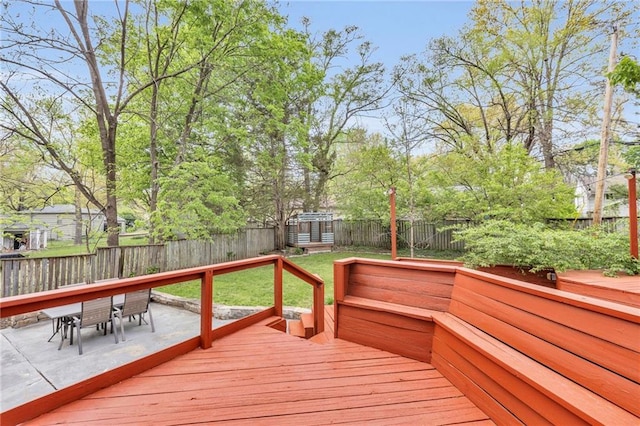 wooden deck with a patio, a fenced backyard, outdoor dining area, and a yard