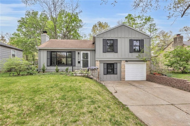 tri-level home with a chimney, board and batten siding, driveway, a front lawn, and an attached garage