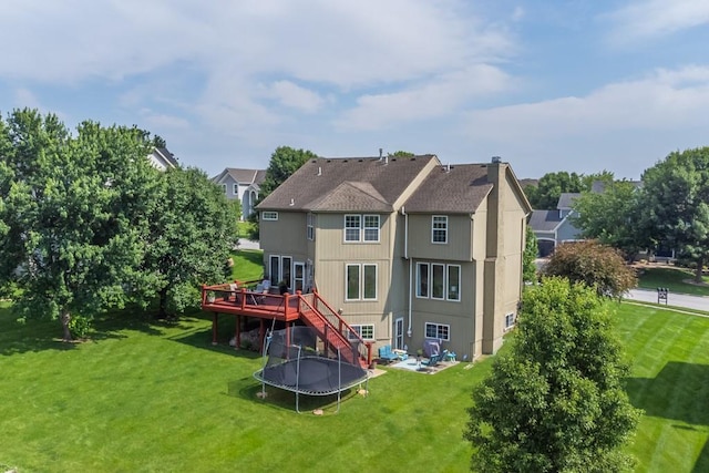14108 Pine Valley Ct, Basehor, KS 66007 - back of property with a wooden deck, a yard, stairs, and a trampoline
